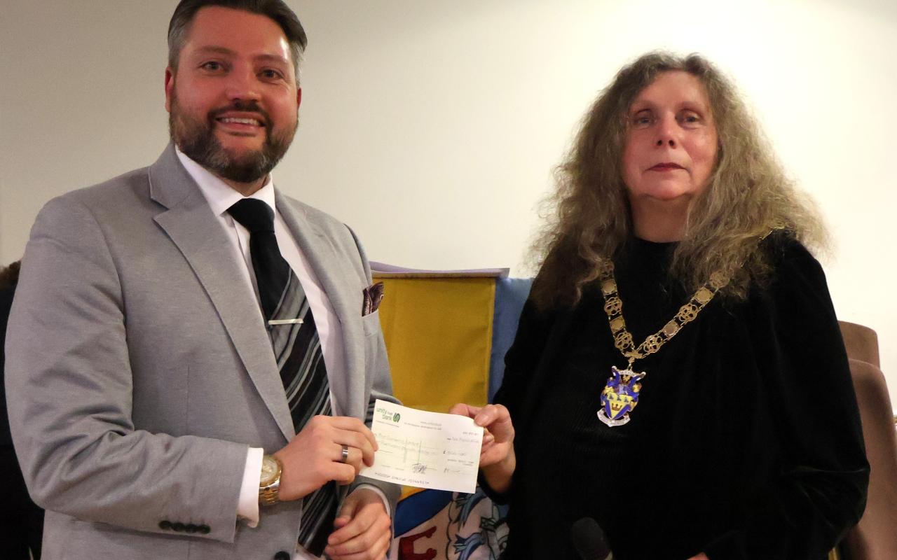 Two people holding a cheque smiling.